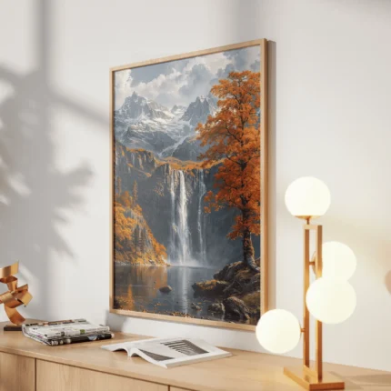 Tall waterfall flowing into a lake beneath snow-capped mountains, surrounded by orange autumn trees and rocky cliffs.
